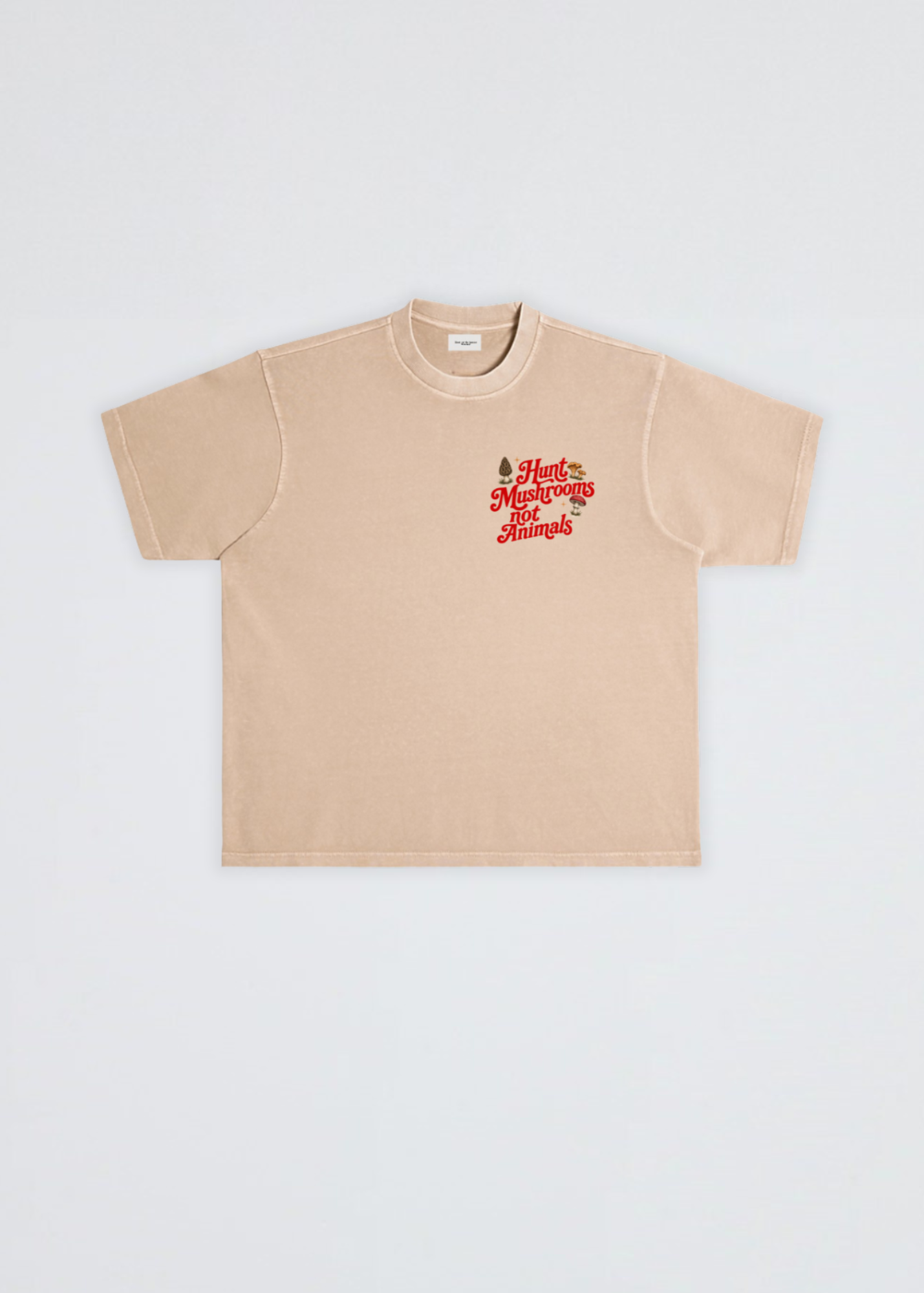 A beige short-sleeve crewneck t-shirt with a red graphic on the left chest reading 'Hunt mushrooms not animals' with a small pine tree illustration, displayed flat against a light gray background.